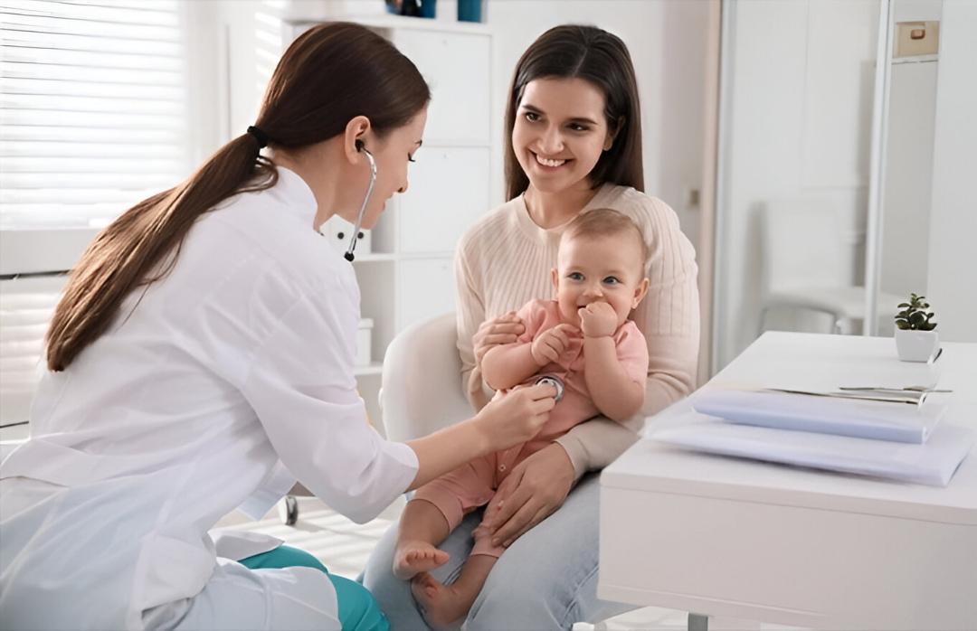 Doctor examining a happy baby in clinic